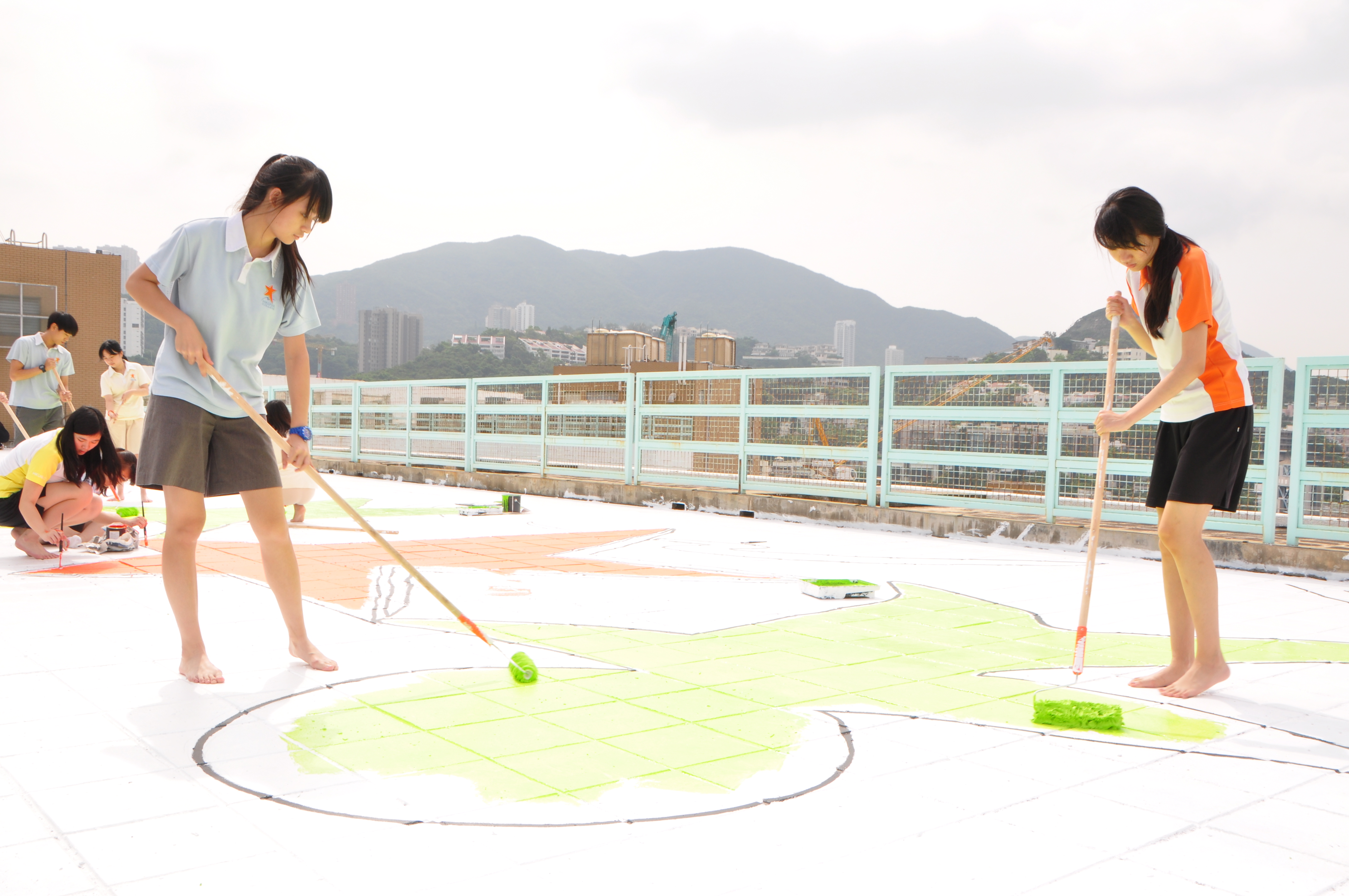 Students using paint rollers
