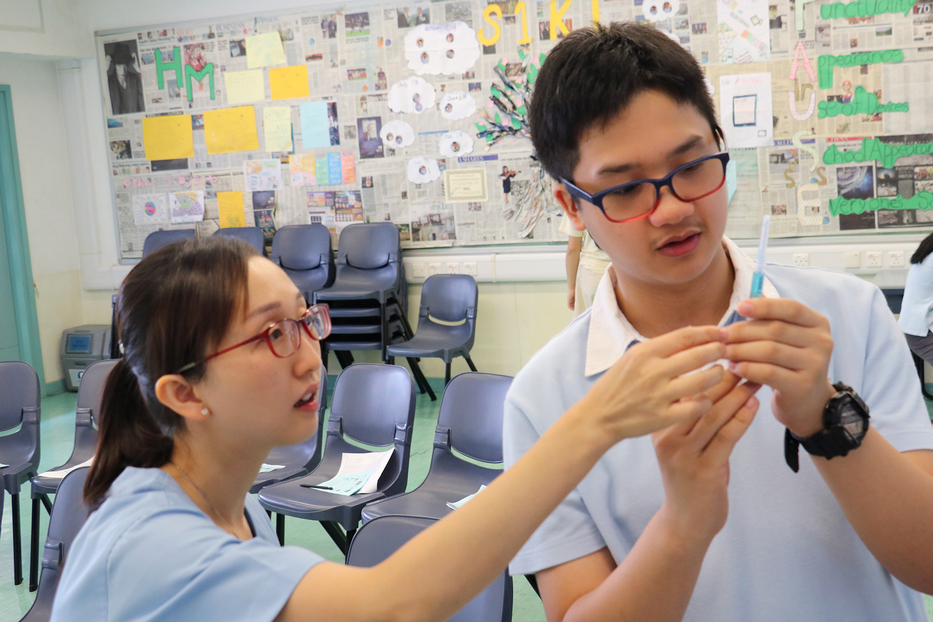 School nurse showing students the procedure of using syringes.